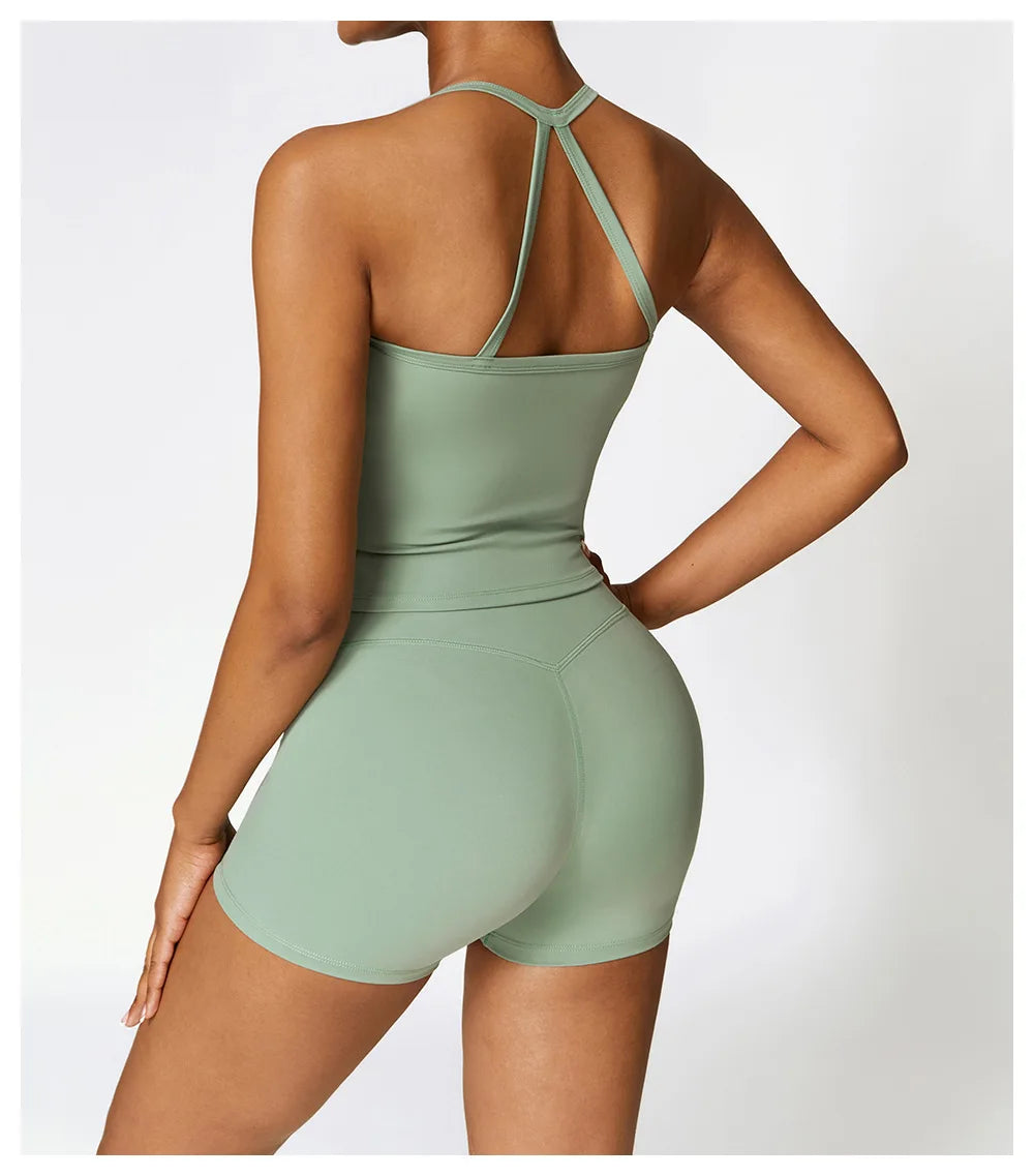 Back view of a woman wearing a green Cross Back Push-Up Sports Bra and matching shorts, showcasing stylish workout attire.