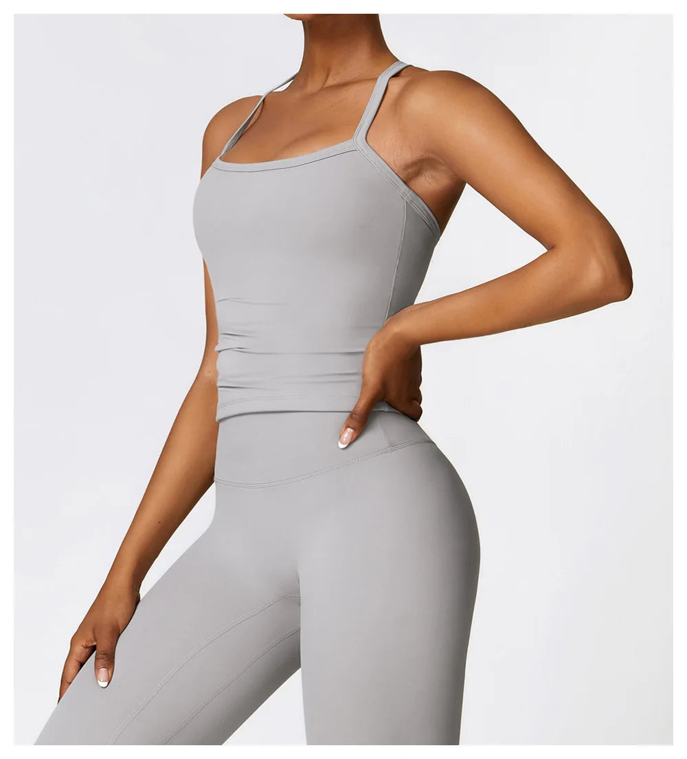 Model showcasing a light grey sports bra with wide straps and high-performance legging.