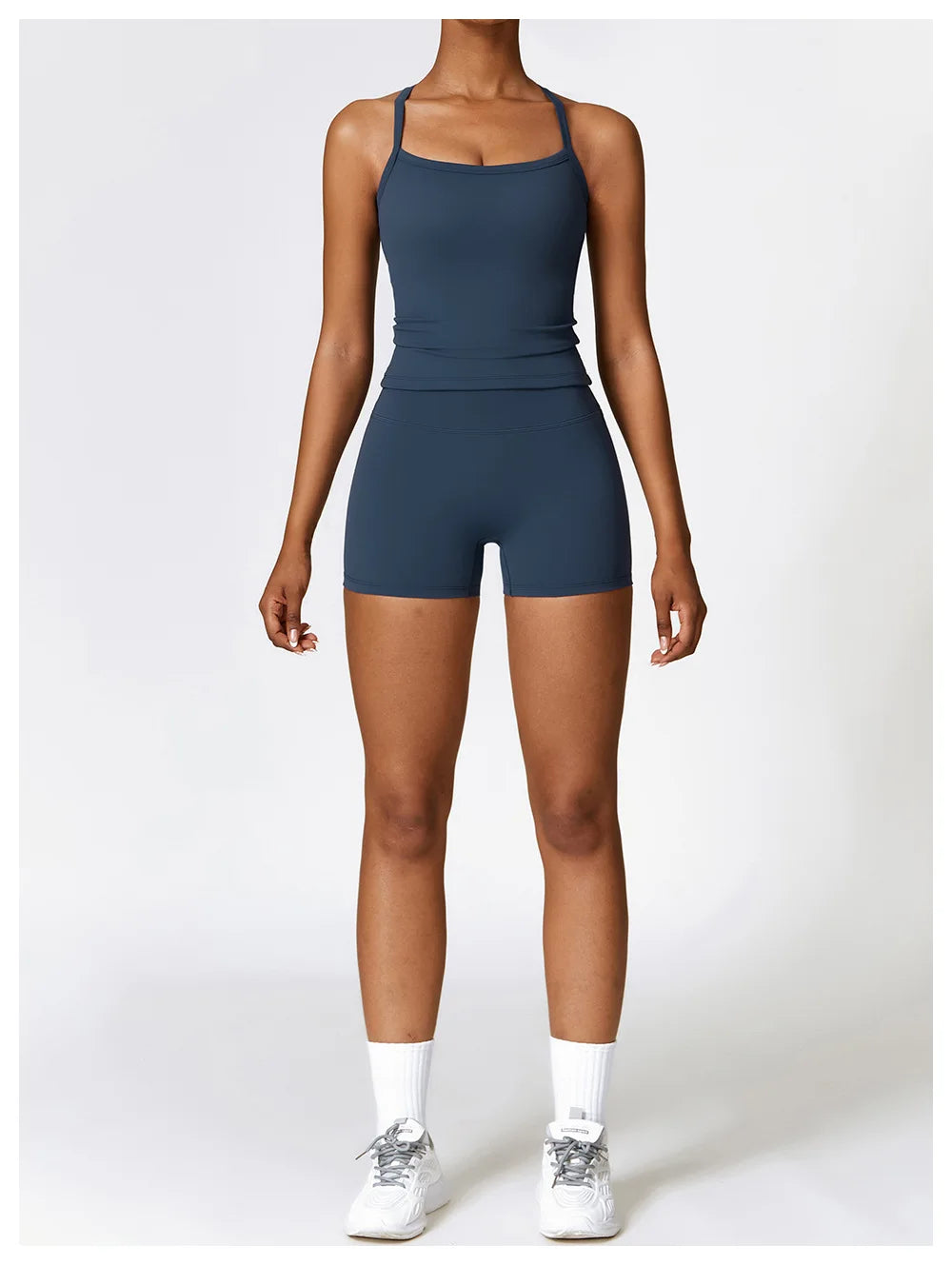 Woman in a dark blue athletic outfit showcasing a fitted tank top and shorts, perfect for sports and casual wear.