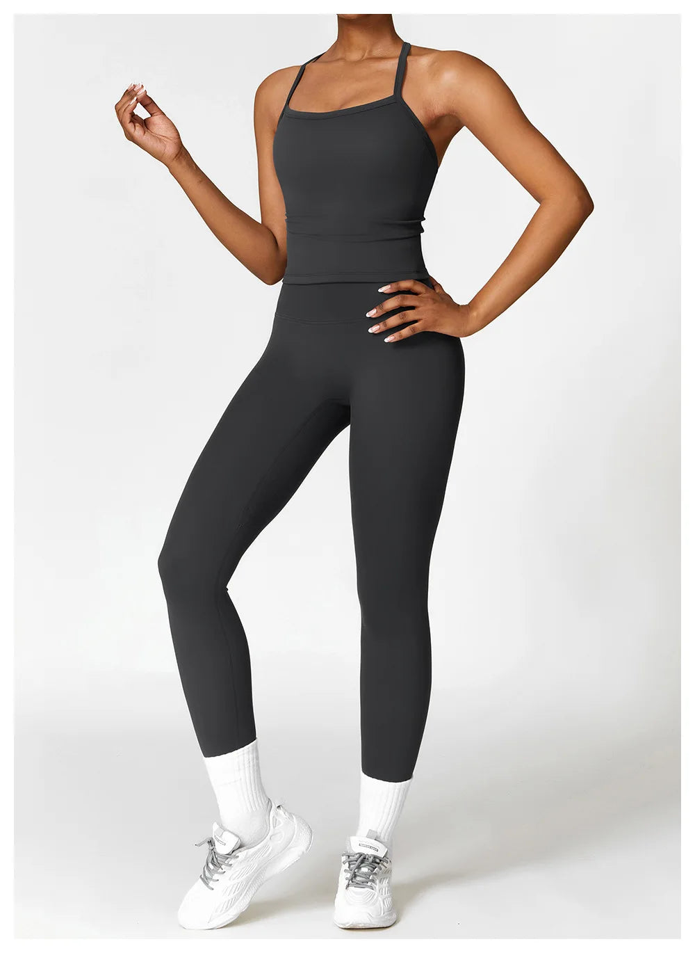 Model wearing black workout outfit featuring a sleek top and leggings, ideal for fitness enthusiasts.