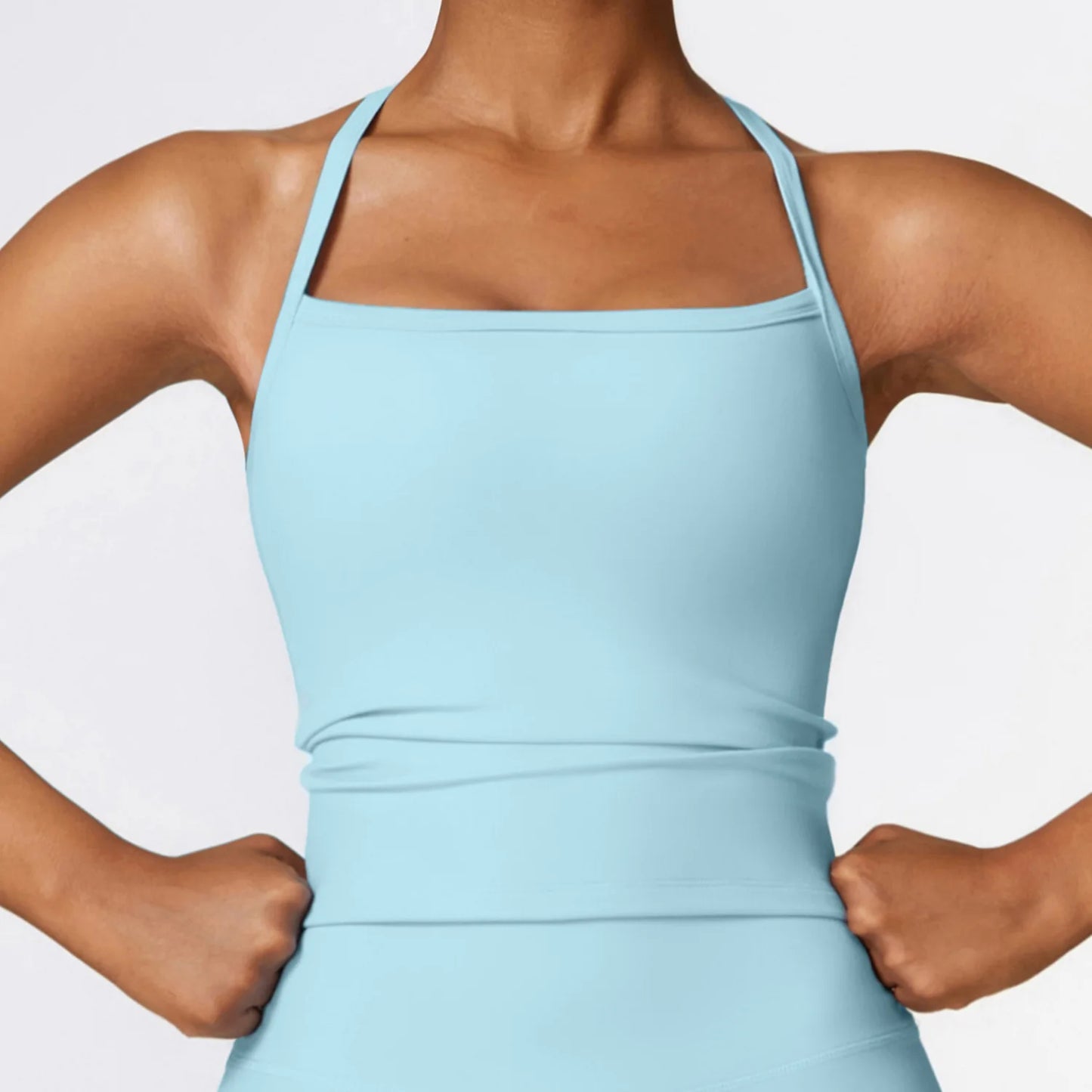 Model showcasing a light blue Cross Back Push-Up Sports Bra with wide straps and supportive fit.