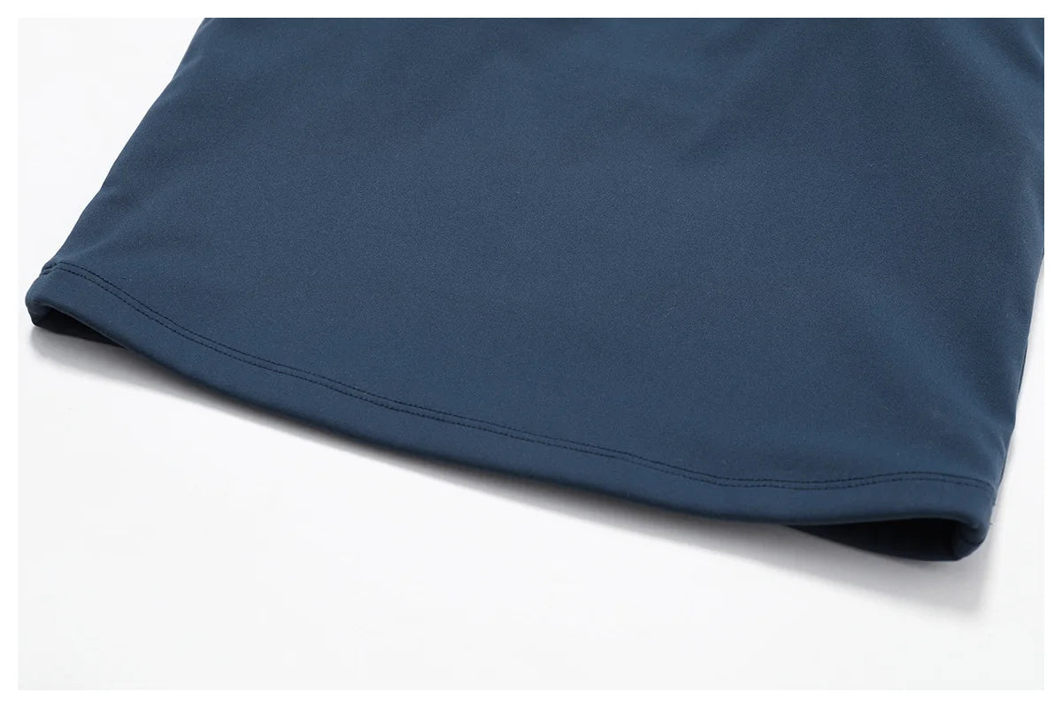 Close-up view of the hem of a navy blue sports bra, showcasing the smooth fabric and stitching details.