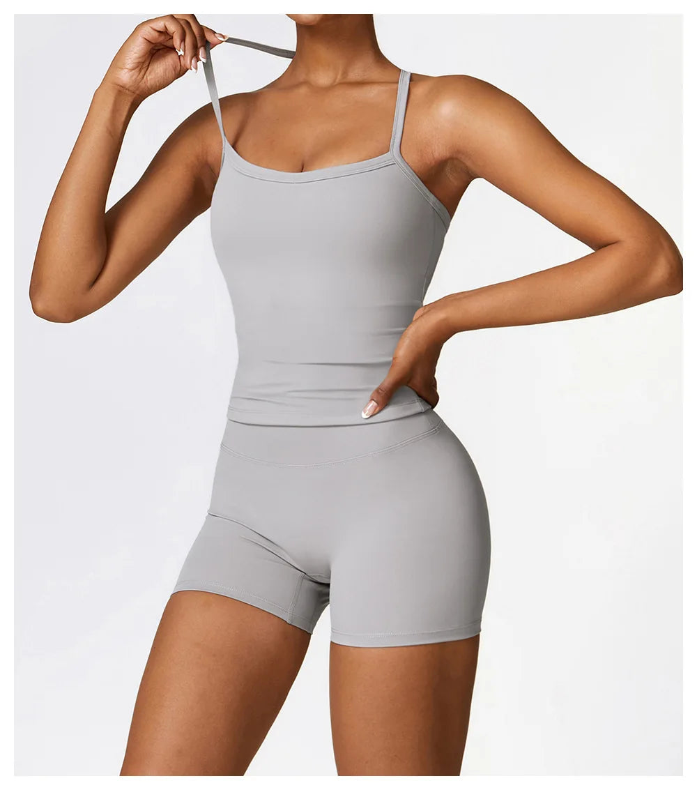 Woman showcasing a grey sports outfit with a fitted tank top and shorts, perfect for workouts and activewear.