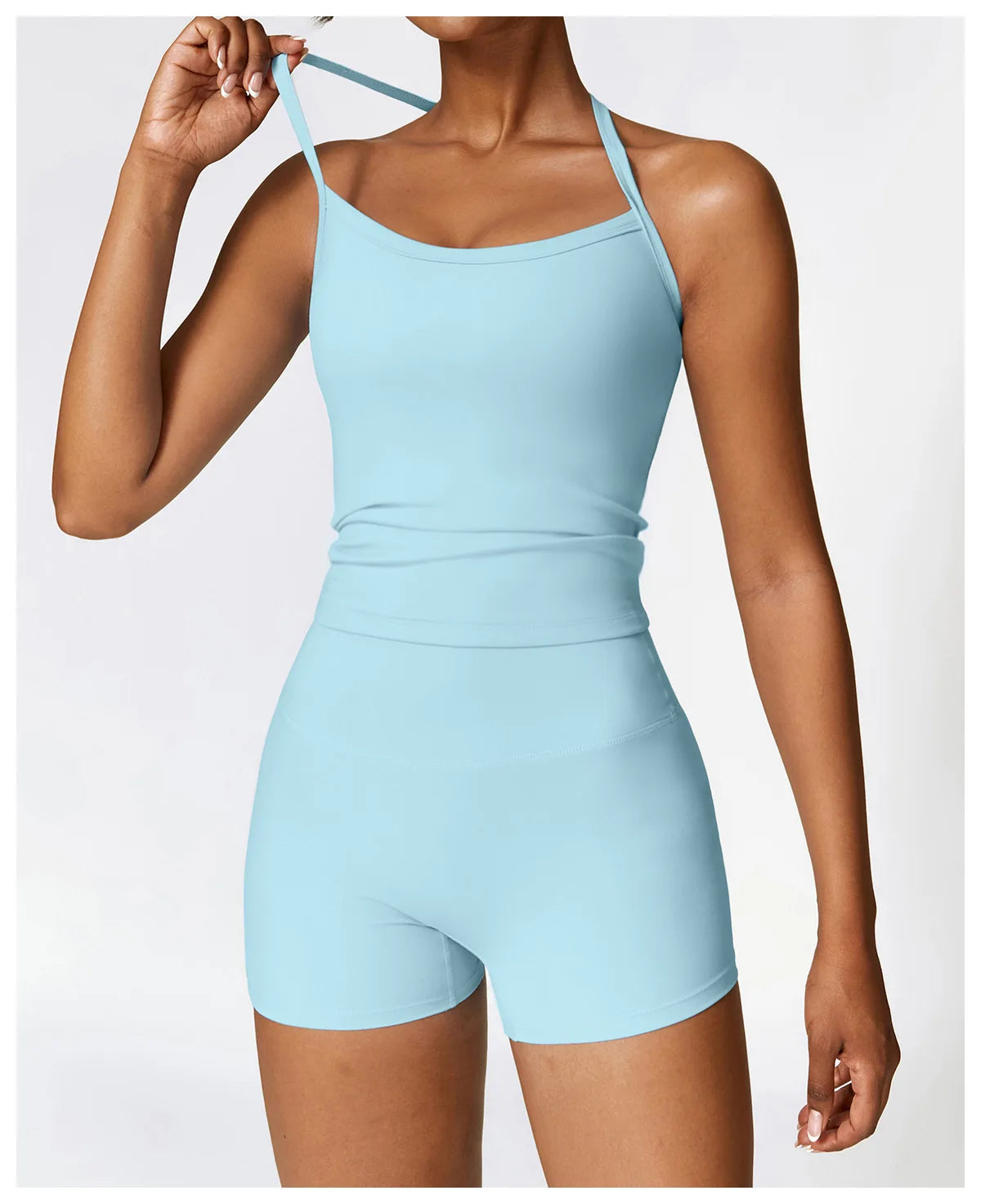 Woman wearing a light blue athletic outfit featuring a fitted tank top and shorts, perfect for workouts.