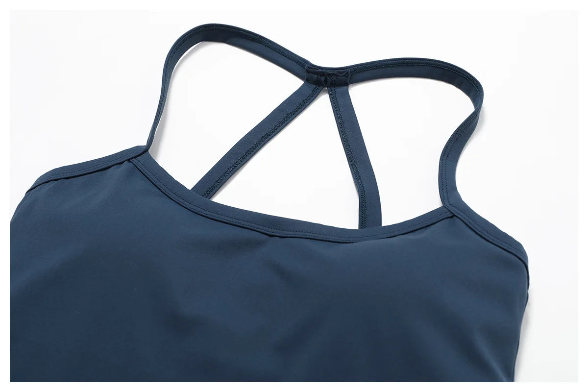 Close-up of the cross back design on a navy blue sports bra, highlighting wide straps and breathable fabric.